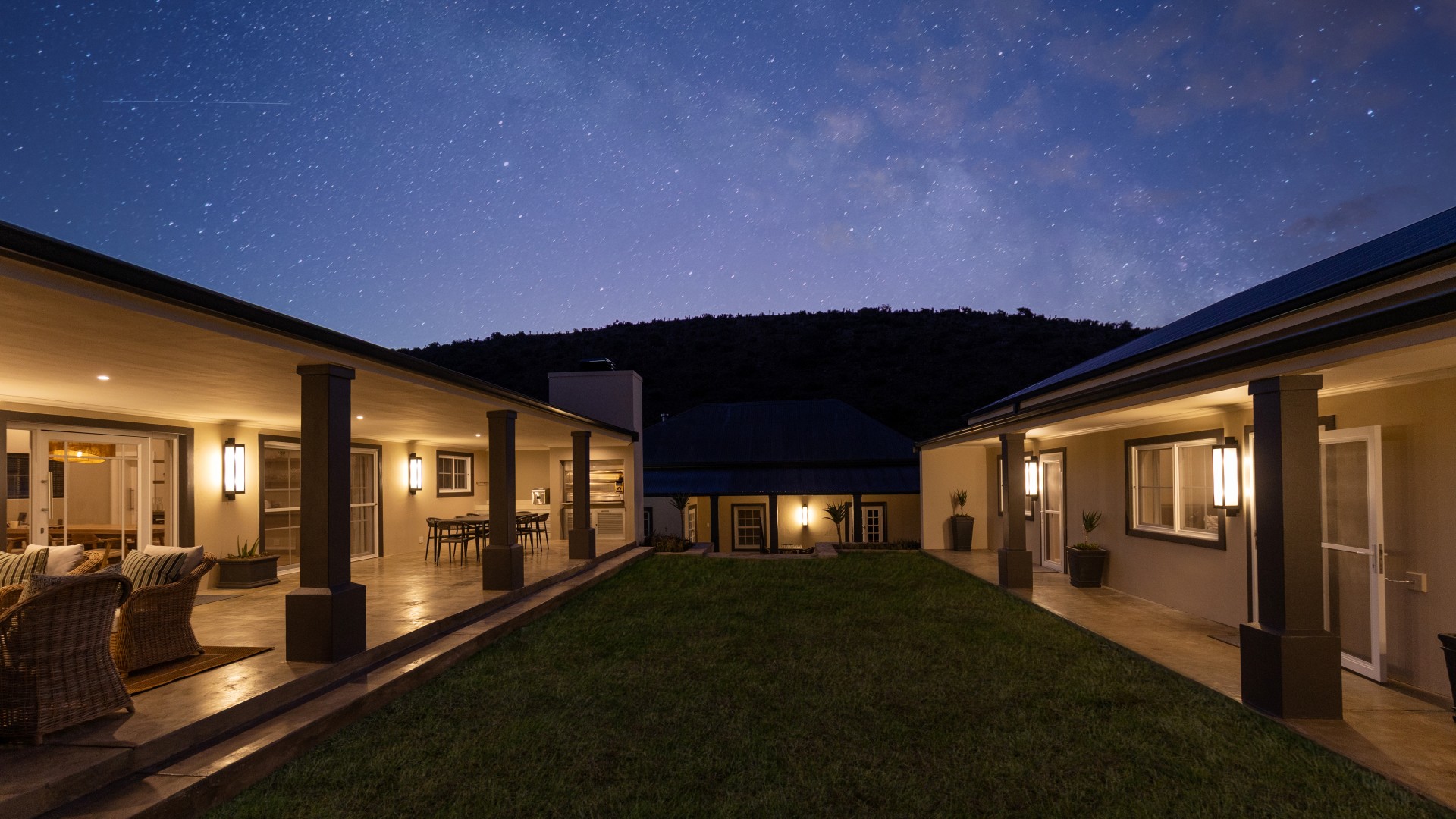 Courtyard house illuminated beneath a star-filled night sky