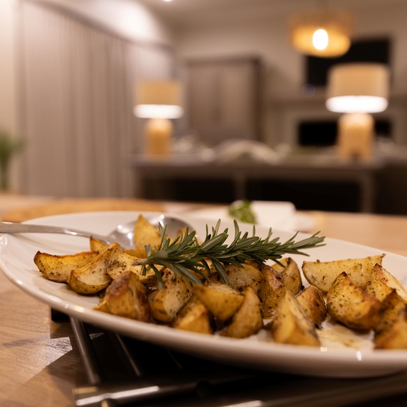 Herb-roasted potato wedges garnished with fresh rosemary