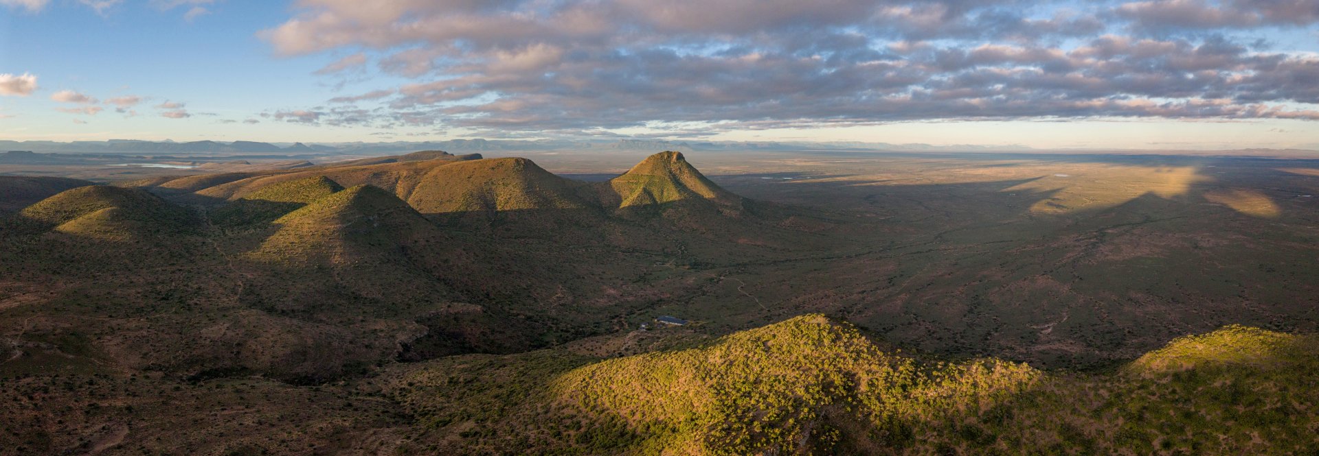 Sunlit volcanic hills overlooking a vast desert plain