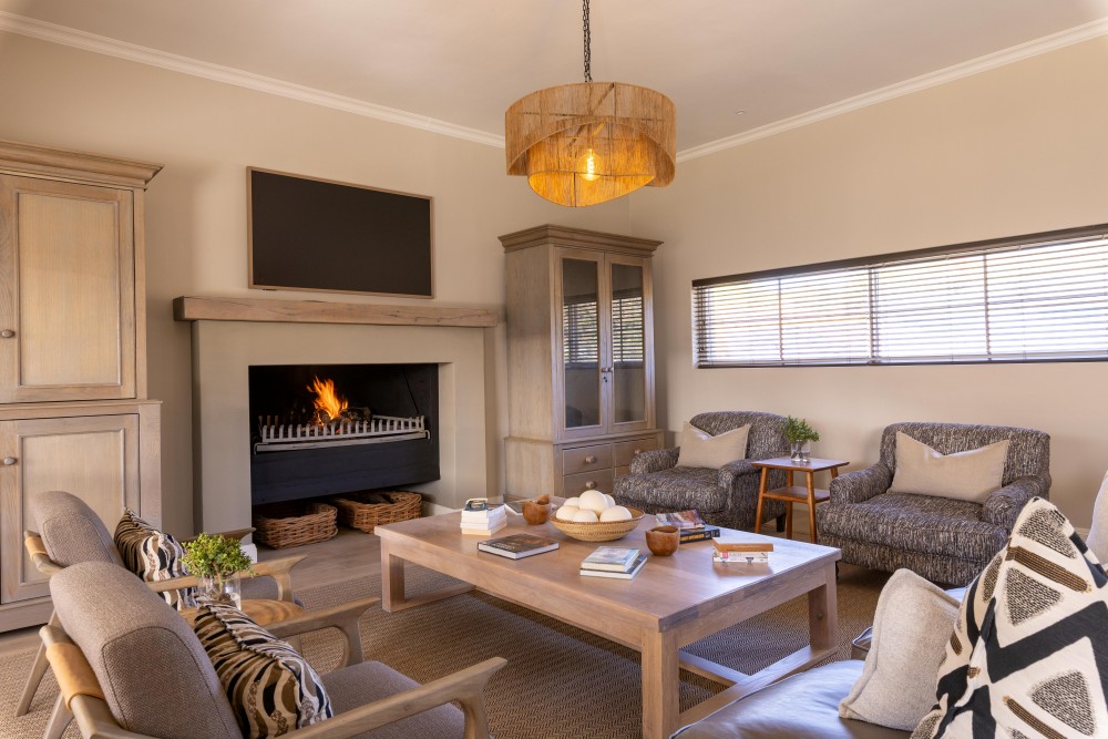 Cozy living room with fireplace, wooden furniture, and armchairs