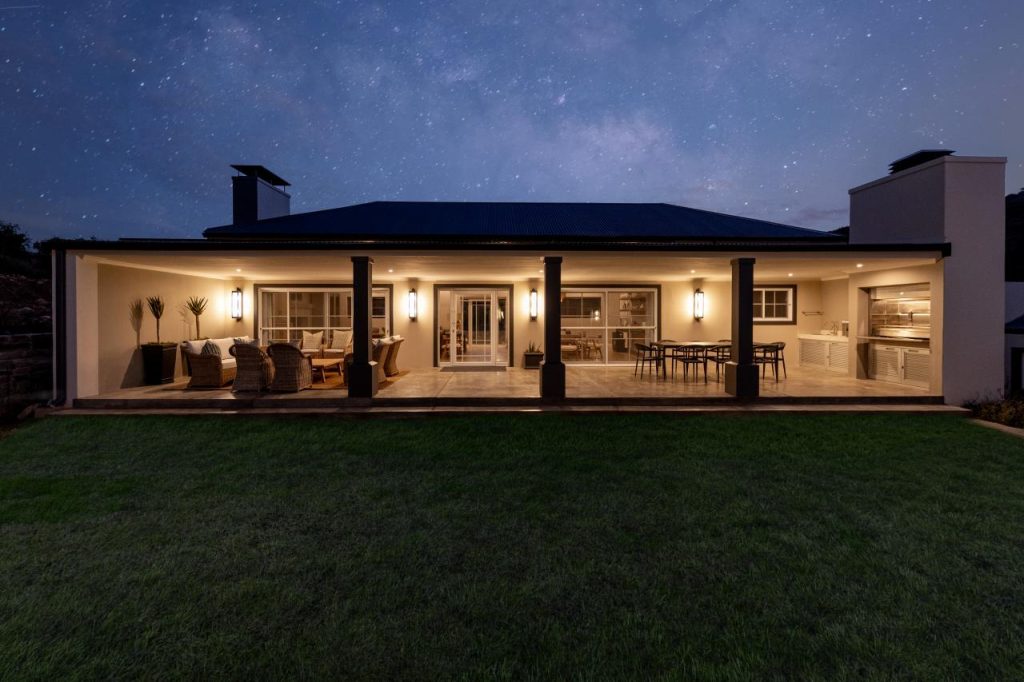 Illuminated modern home patio under a starry night sky
