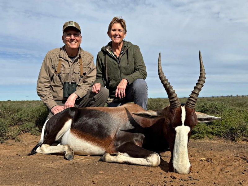 Two hunters pose behind a harvested blesbok antelope.
